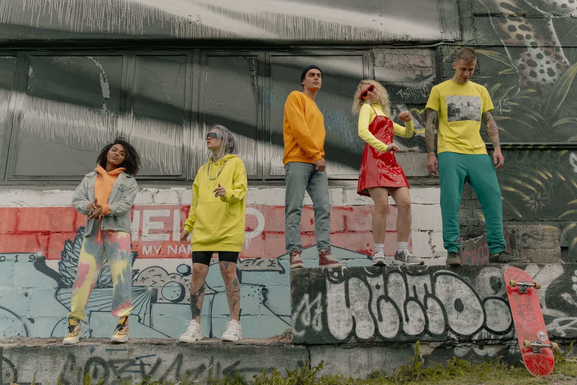 Group dancing beside a graffiti wall